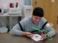 Student holding a chemical model studying at a table.