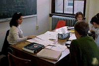 Peer Mentor Tutor working with a small group of students around a table.